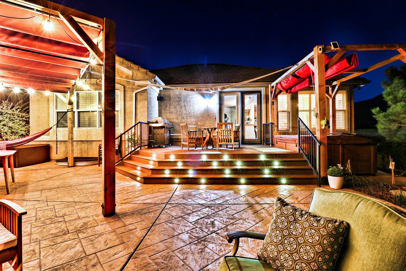 A deck and pergola lit at dusk