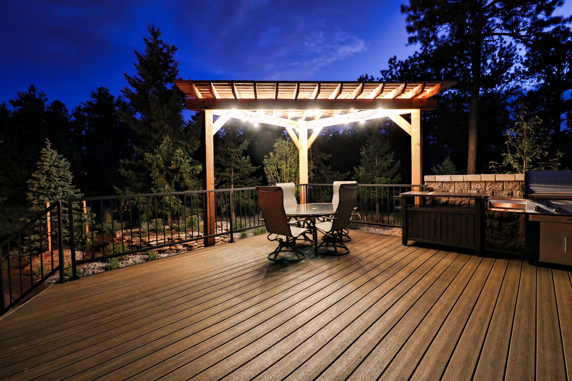 A lit cedar pergola over a composite deck at dusk in Black Forest, Colorado